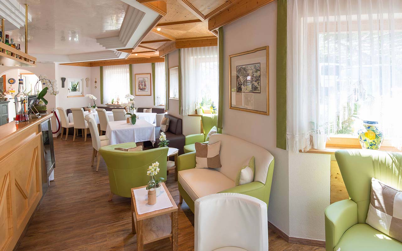 Die grünen und weißen Sessel und Sofa der Bar im Hotel Fleuralp in Tscherms