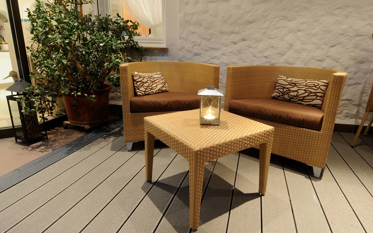 Relax corner with wicker chairs and tables and a lighted candle
